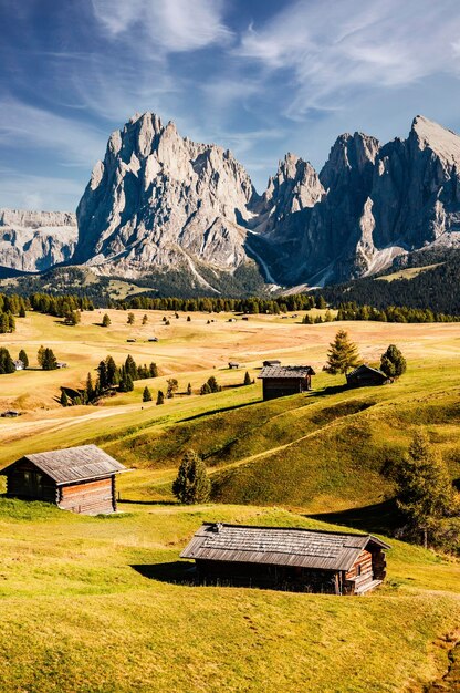 Photo alpe di siusi seiser alm langkofel mountain group landscape of alpine red autumn alpe di siusi hiking nature scenery in dolomites wooden chalets in dolomites trentino alto adige