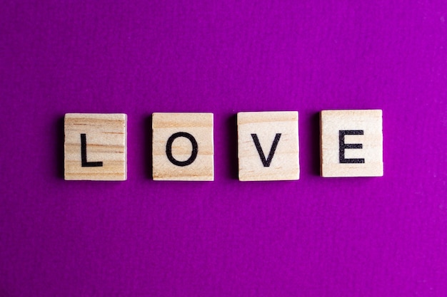 Alphabet blocks with letters on a pink background. inscription LOVE.