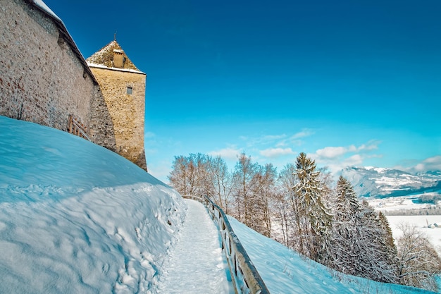 Alpine mountains and Gruyeres Castle in Gruyeres town village in Switzerland, in winter