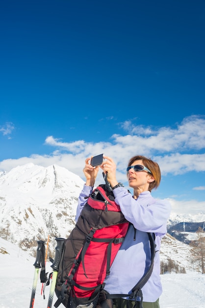 Alpinist taking picture with phone