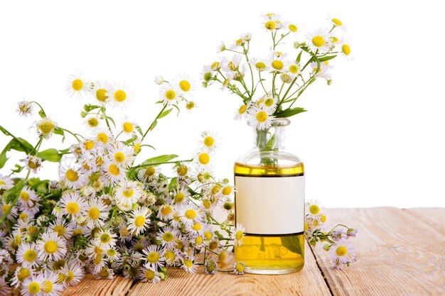 Alternative medicine concept bottle with camomile on wooden table