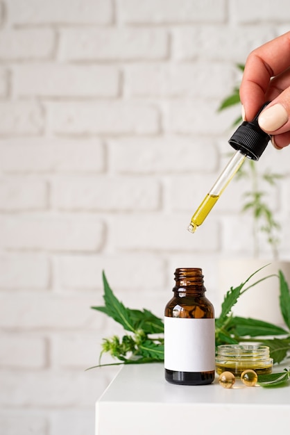 Alternative medicine, natural cosmetics. cbd oil and cannabis leaves cosmetics front view , copy space, mock up design