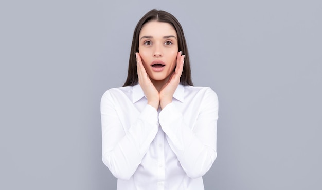 Amazed businesslady in white shirt on grey background success