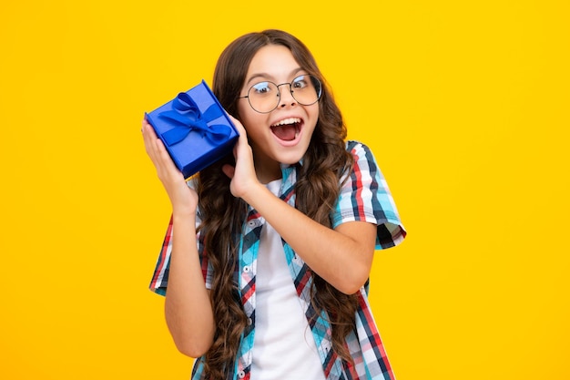 Amazed teen girl Child with gift present box on isolated background Presents for birthday Valentines day New Year or Christmas Excited expression cheerful and glad