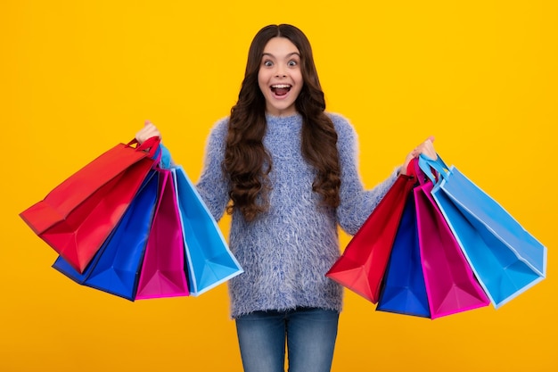 Amazed teenager Shopping bags in the kids hands Teen girl after shopping Purchases black friday