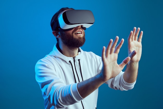 Amazed young bearded man touching the air during the vr experience