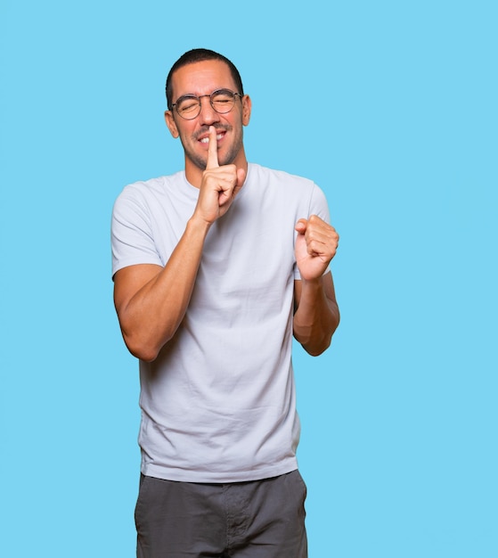 Amazed young man asking for silence gesturing with his finger