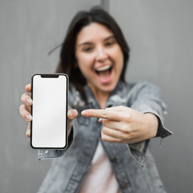 Amazed young woman showing smartphone