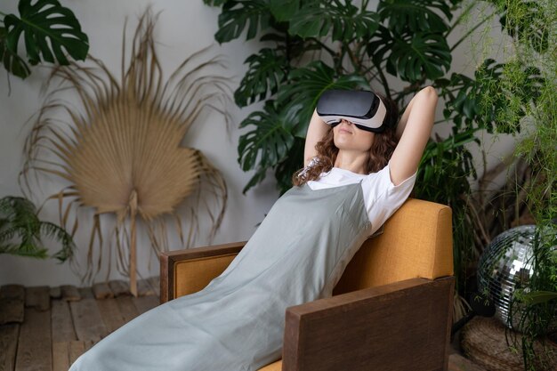 Photo amazed young woman using vr in home garden resting in relaxing virtual environment cyberspace