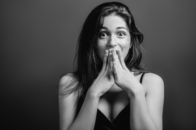 Amazed young woman with wide open eyes Shock facial expression Black and white portrait Copy space