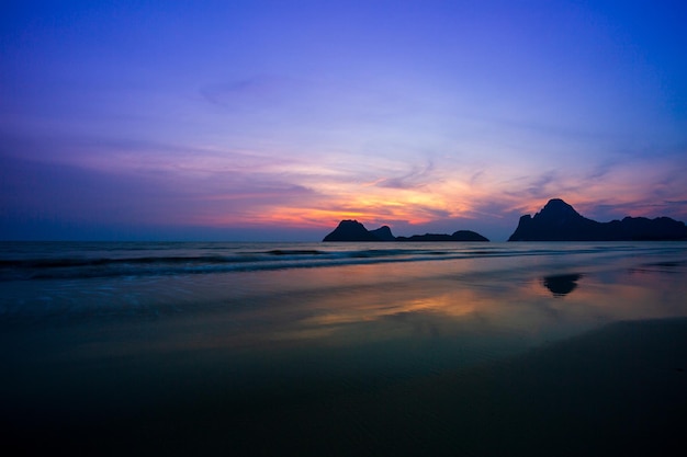 Amazing beach sunset with endless horizon and lonely figures in the distance and incredible foamy w