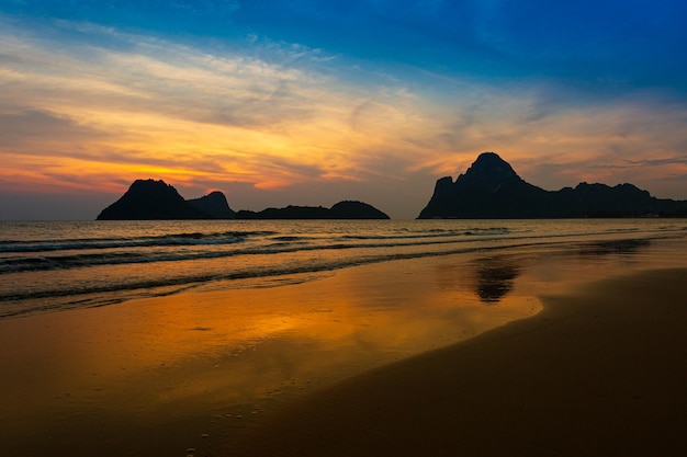 Amazing beach sunset with endless horizon and lonely figures in the distance and incredible foamy