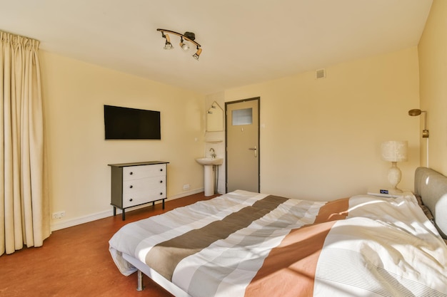 Amazing bedroom with striped bedspread on the bed and orange floor