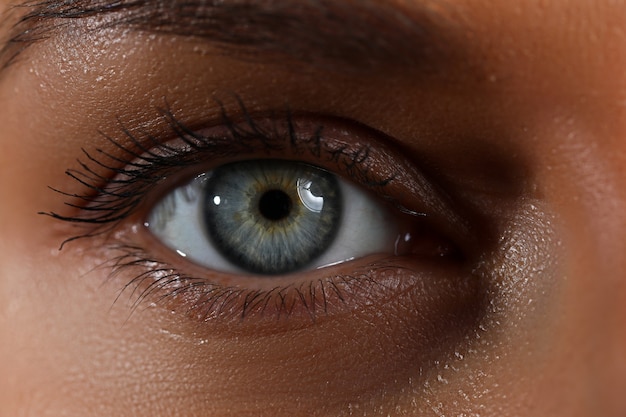 Amazing female blue and green colored wide opened eye in low light technique close-up