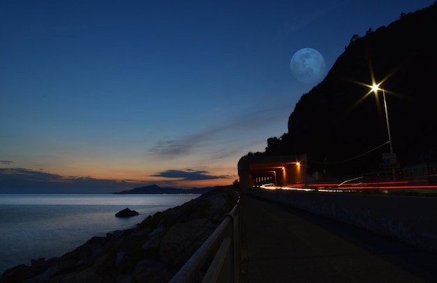 Amazing giant moon reflected on the sea on the Ligurian coast