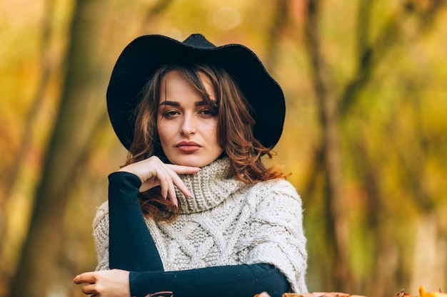 Amazing girl in a black hat and knitted sweater