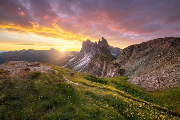 Amazing landscapes view of green mountain with gold sky on sunrise morning from Dolomites, Italy.