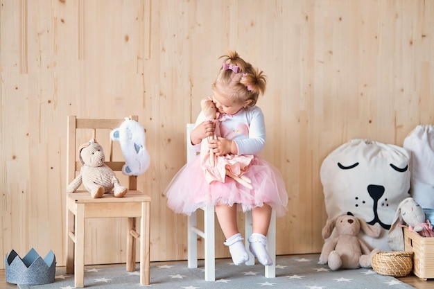 Amazing little girl playing with a doll in her roomx9