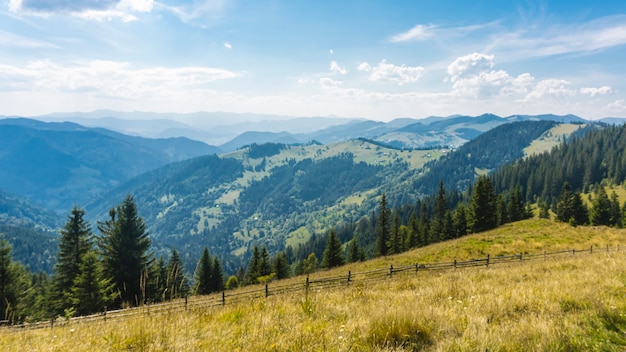 Amazing mountain landscape with blue sky with white clouds, sunny summer day in Carpathians, Ukraine. Natural outdoor travel background.