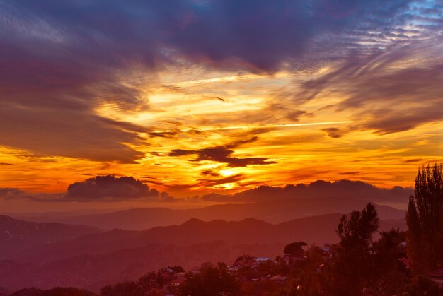 Amazing mountain landscape with colorful vivid sunset on the bright sky, natural outdoor travel background