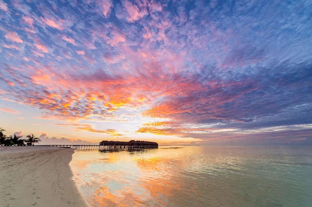 Amazing panoramic sunset Maldives. Luxury resort villas seascape, sea horizon water reflection