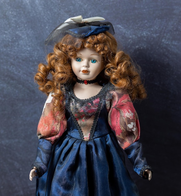 Amazing realistic vintage porcelain doll toy with blue eyes The doll dressed in a redblue dress and has a red hair