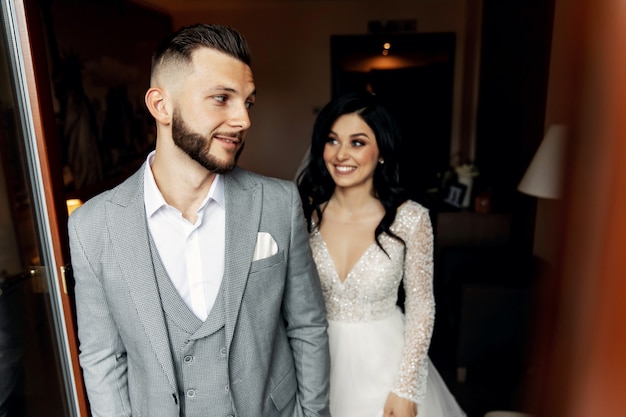 Amazing smiling wedding couple. Pretty bride and stylish groom.