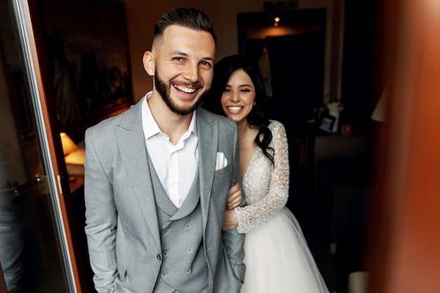 Amazing smiling wedding couple. Pretty bride and stylish groom.