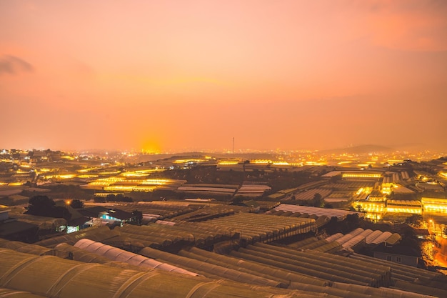 Amazing sunset landscape in agricultural greenhouse valley in Da Lat City The light from the greenhouse to grow flowers in Da Lat Travel and landscape concept