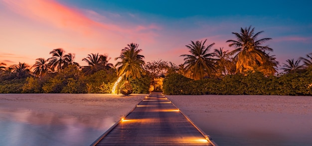 Amazing sunset panorama at Maldives. Luxury resort villas seascape with soft led lights, dream shore