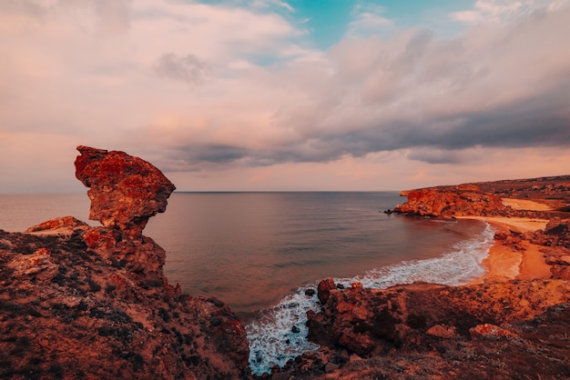 Amazing sunset at sea, beauty of nature. Scenic view of the sea, rocky coastline and sandy beach, golden sky and sun, outdoor travel background. General's beaches. Crimea.