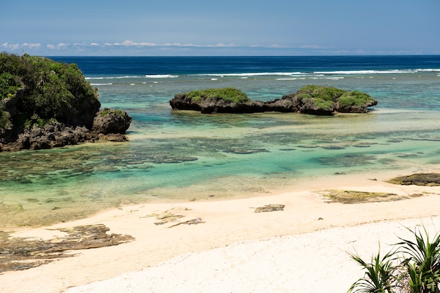 Amazing transparent emerald green sea full of corals. Islet, white sand.  Iriomote island