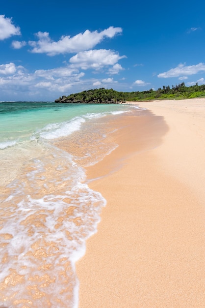 Amazing turquoise crystal clear water at seashore gentle waves breaking on sand blue sky