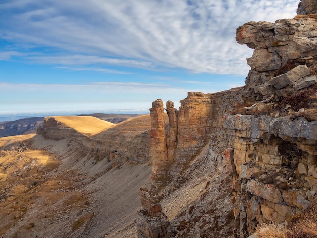 Amazing view of Bermamyt plateau rocks on sunny day Caucasus Mountains on the edge of a cliff in the distance Atmospheric landscape with silhouettes of mountains KarachayCherkessia Russia