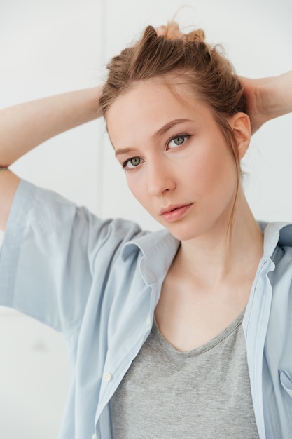 Amazing young caucasian lady painter standing over white wall