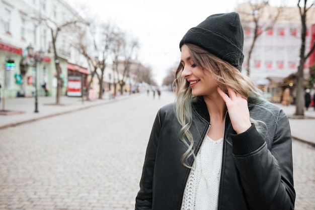 Amazing young lady wearing hat walking on the street