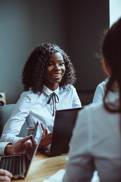 The ambitious afroameriacan girl discussing financial plans for the company team of young diverse bu...