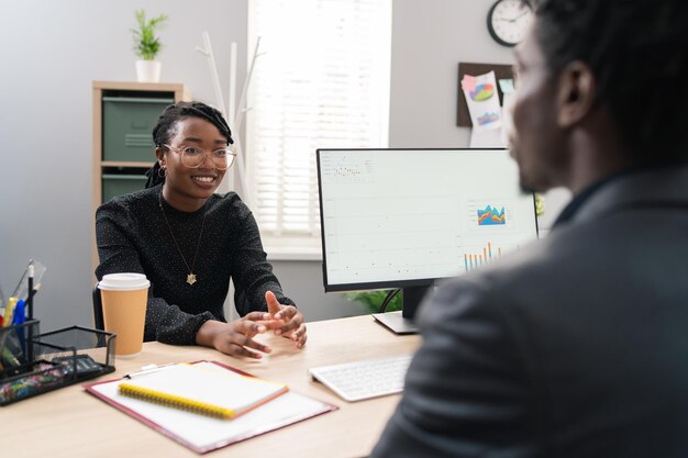 Ambitious beautiful woman with glasses sits at employers desk job interview tells about herself