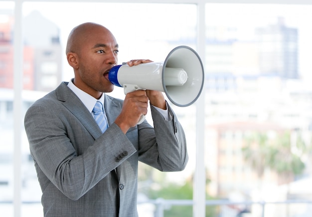 Ambitious businessman yelling through a megaphone