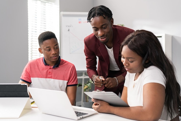 Ambitious young worker talks with boss and colleague discusses reports documents