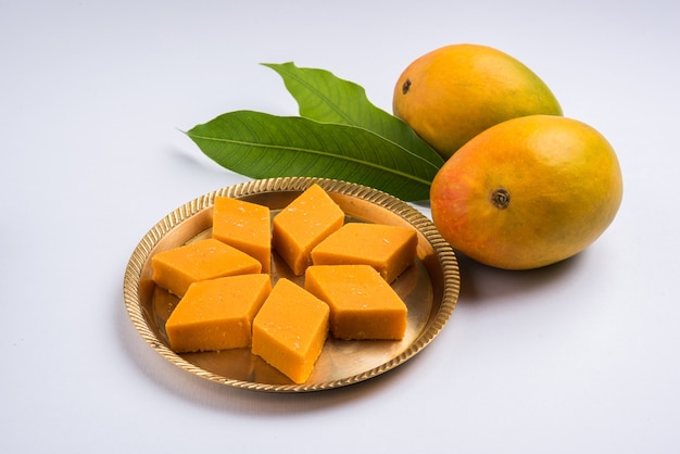 Photo ambyachi vadi or mango burfi or barfi or cake from india is made using authentic alphonso fruit mixed with khoya. served in a plate, selective focus