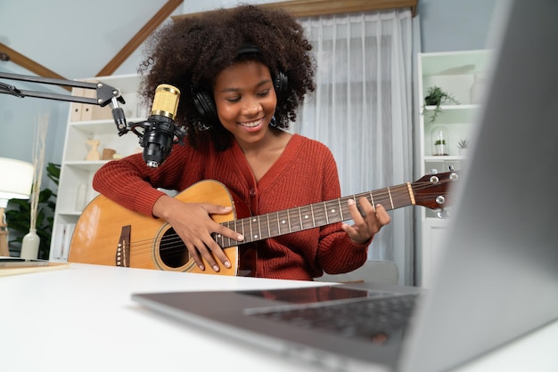 Photo american african broadcasting on laptop with playing guitar tastemaker