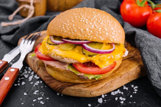 American burger with chicken cutlet on wooden tray