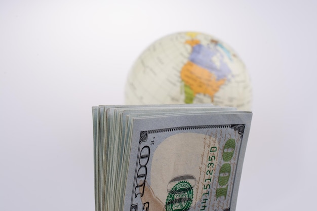 American dollar banknotes by the side of a model globe