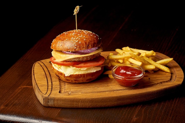 American fast food chicken burger on a wooden board. Dark wooden background. Selective focus.