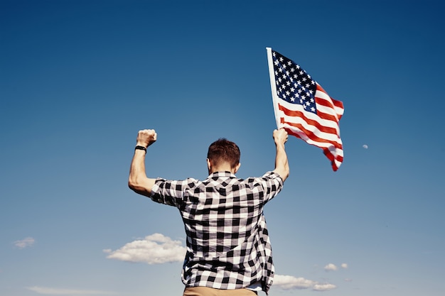 American flag outdoors man holds usa national flag against blue cloudy sky th july independence day