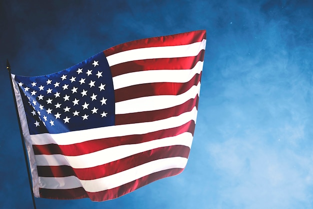 American flag waving in the air with a blue sky