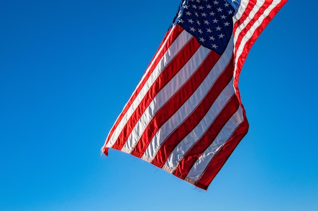 An American flag waving in the blue sky