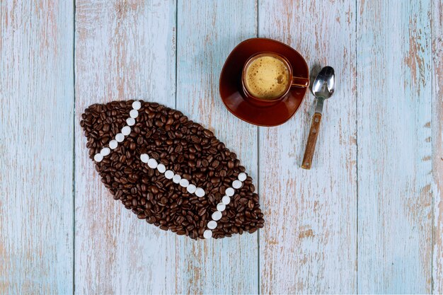 American football ball made from coffee beans with cup of fresh coffee