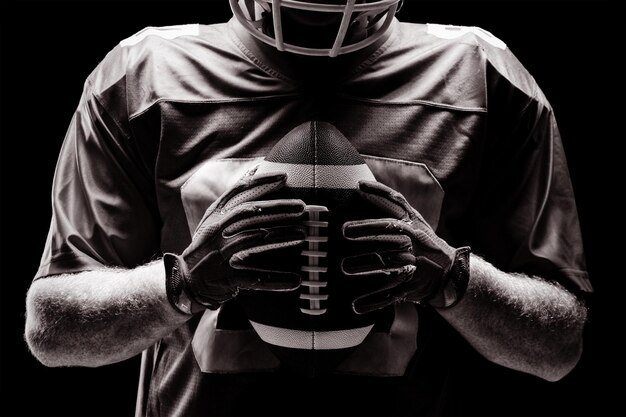 American football player holding rugby ball